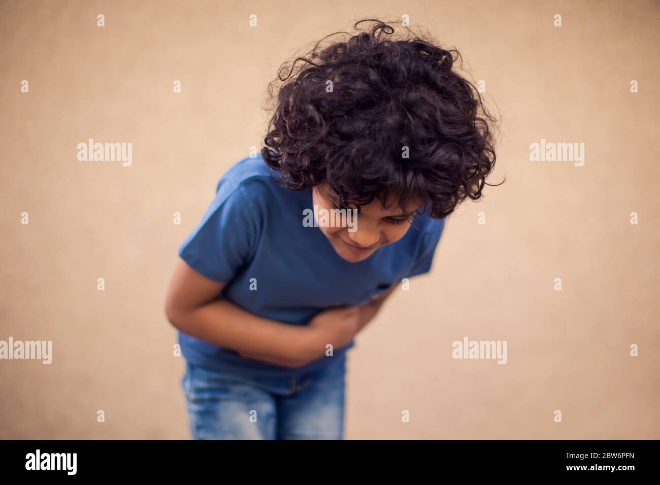 Il ragazzo di capretto sente il dolore forte dello stomaco. Concetto di bambini, sanità e medicina Foto Stock