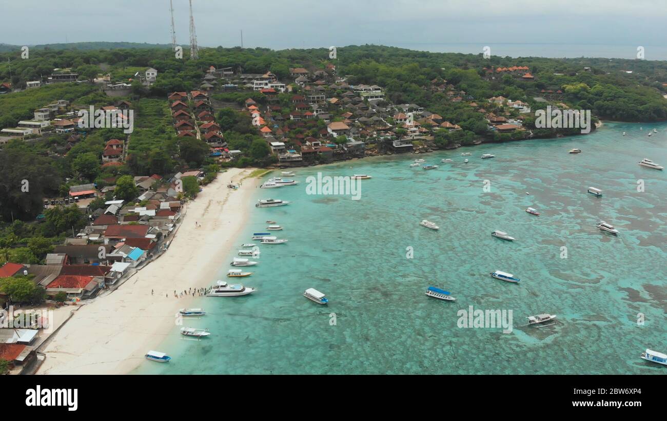 Costa villaggio Jungut Batu con barche e alberghi sull'isola di Lembongan. Indonesia. Vista aerea. Foto Stock