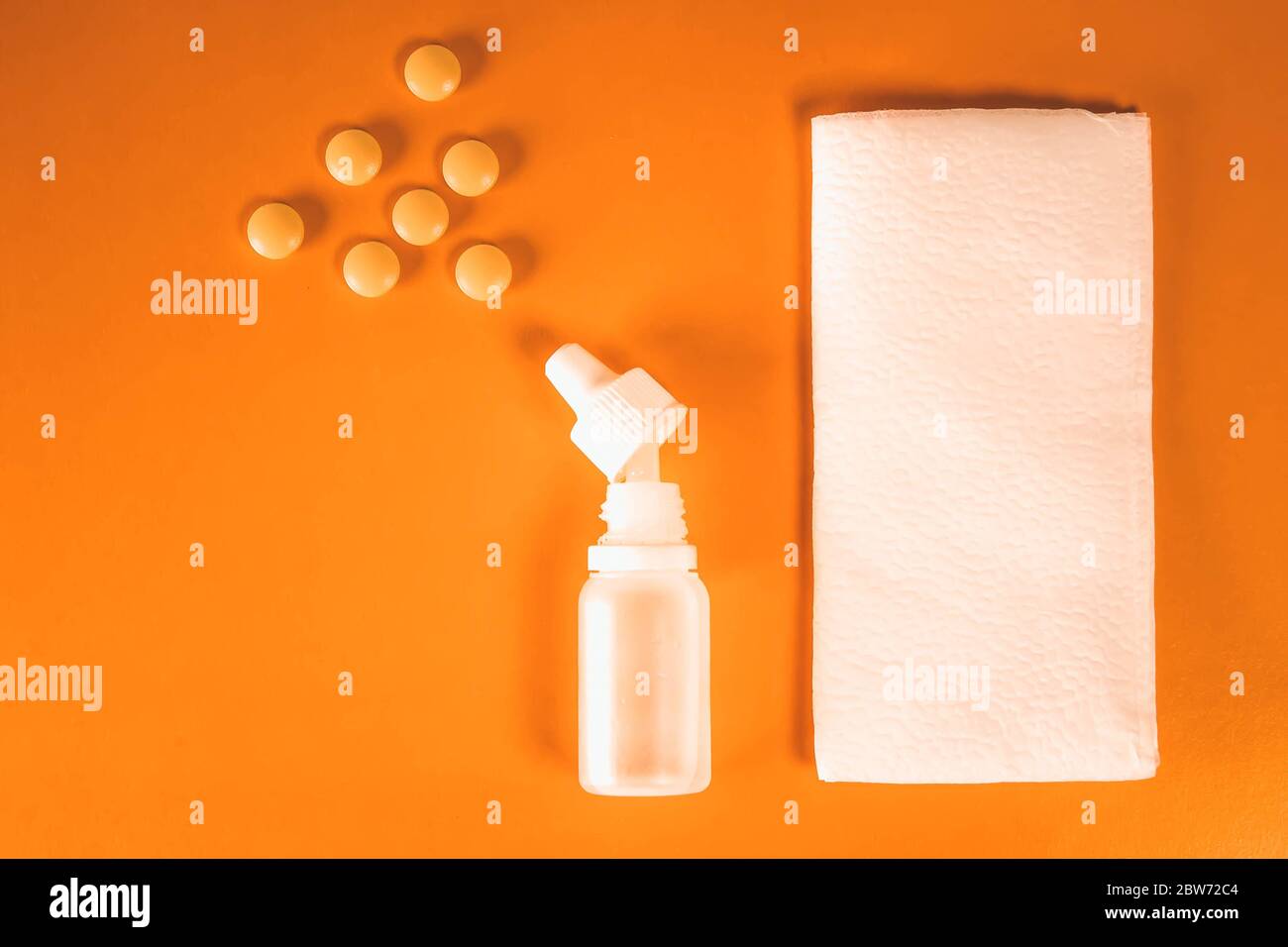 Spray nasale in plastica bianca con compresse e fazzoletti di carta su  sfondo arancione - sinusite, geniantrite, rinite e altre malattie di ENT  orga Foto stock - Alamy