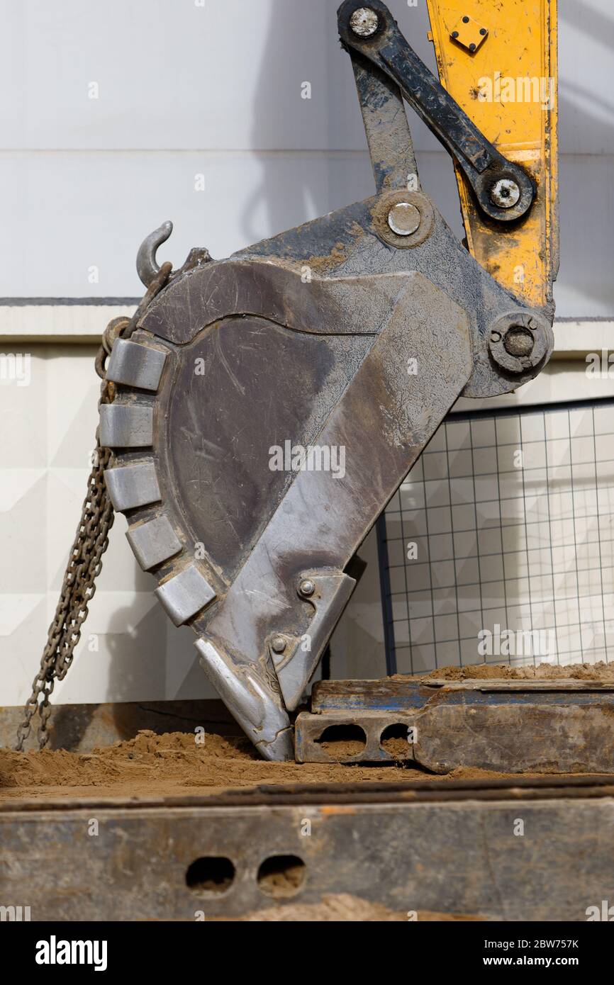 Primo piano della benna dell'escavatore (livellatrice, trattore) con catene nel cantiere Foto Stock