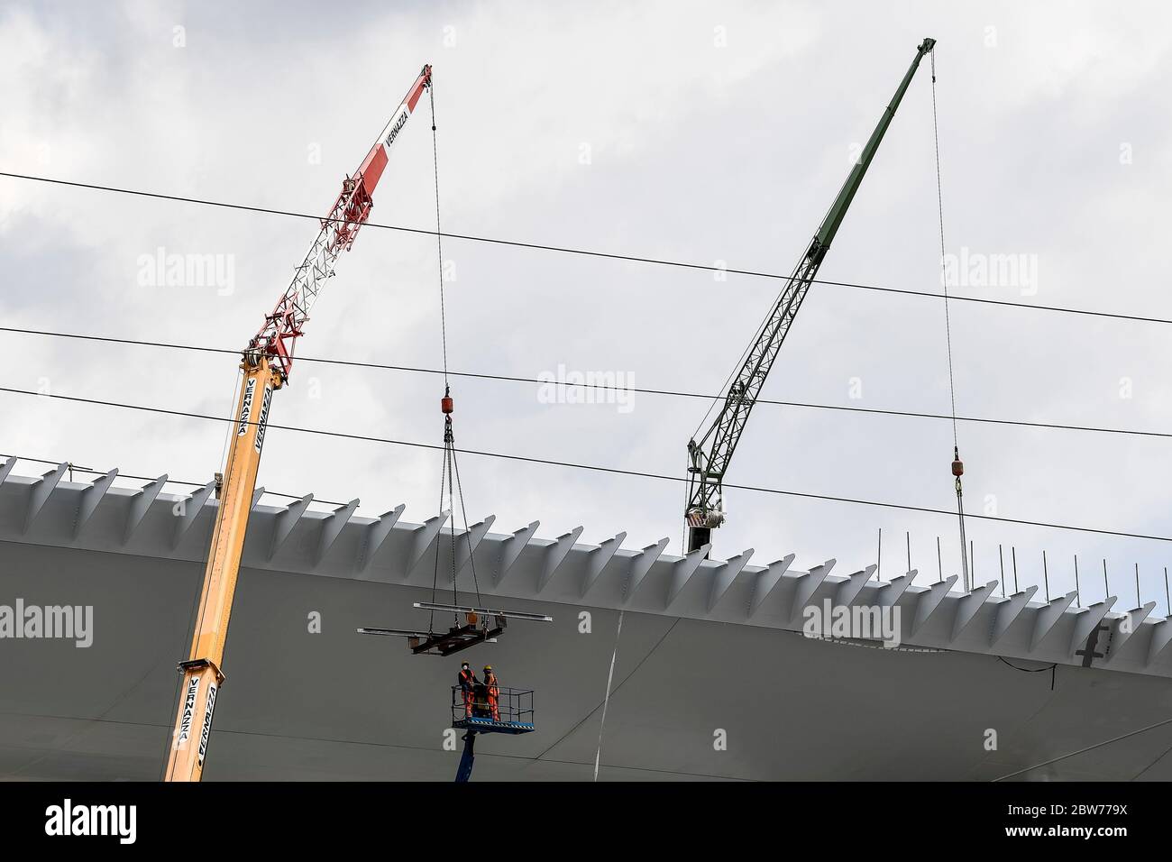 Genova, Italia - 29 maggio 2020: Due uomini al lavoro sono visti nel cantiere del nuovo ponte Morandi (ufficialmente Viadotto Polcevera). Il ponte originale crollò nell'agosto 2018 e quello nuovo dovrebbe riaprirsi nel luglio 2020. Credit: Nicolò campo/Alamy Live News Foto Stock
