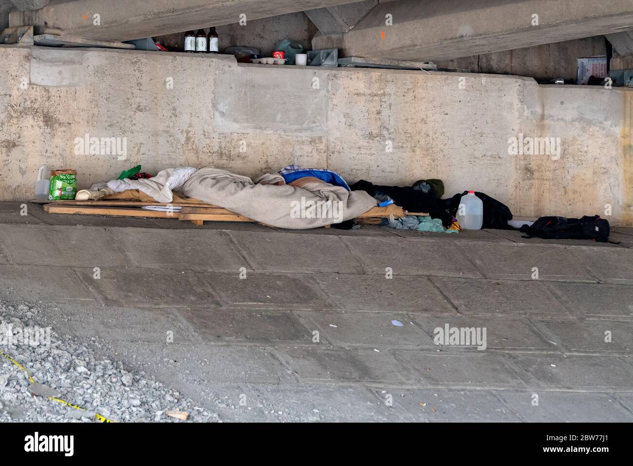 San Giovanni, NB, Canada - 2 giugno 2019: Il luogo in cui una persona senza tetto vive sotto un ponte. C'è un letto realizzato localmente, alcuni vestiti e altri oggetti. Foto Stock