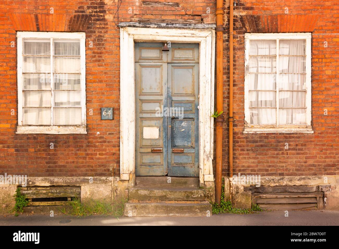 La porta e la facciata di vecchie case del diciannovesimo secolo che necessitano di un rinnovo, Bewdley Worcs UK Foto Stock