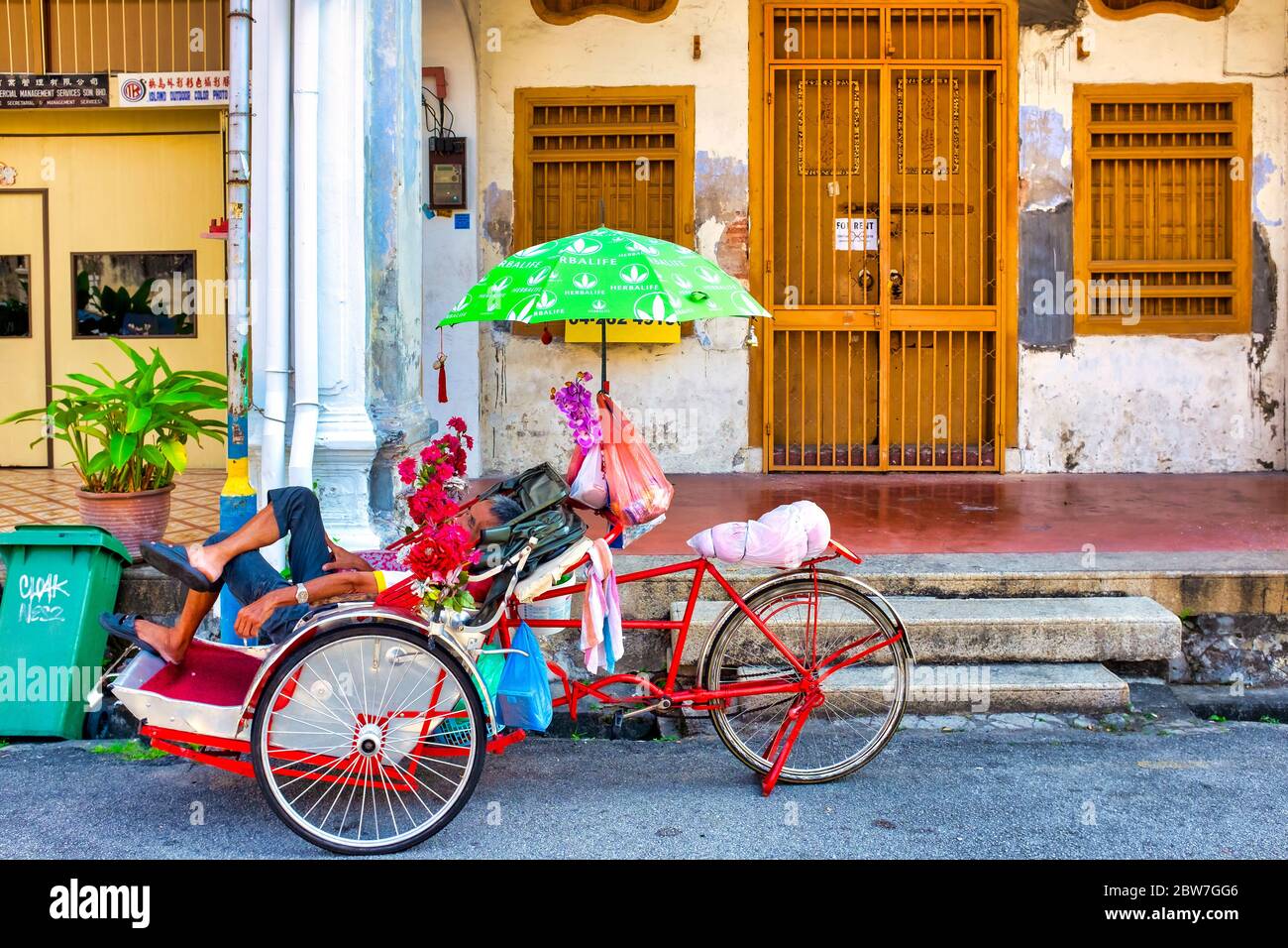 Autista del Cycle Rickshaw che dorme in George Street, George Town, Penang, Malesia Foto Stock