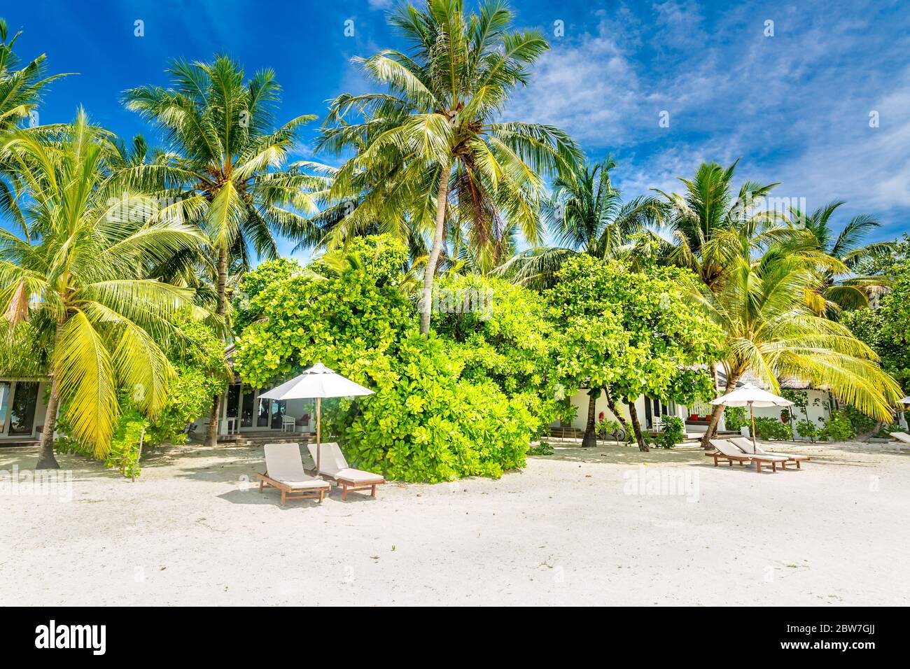 Sedie da spiaggia con ombrellone a isole Maldive, spiaggia di sabbia bianca e mare Foto Stock