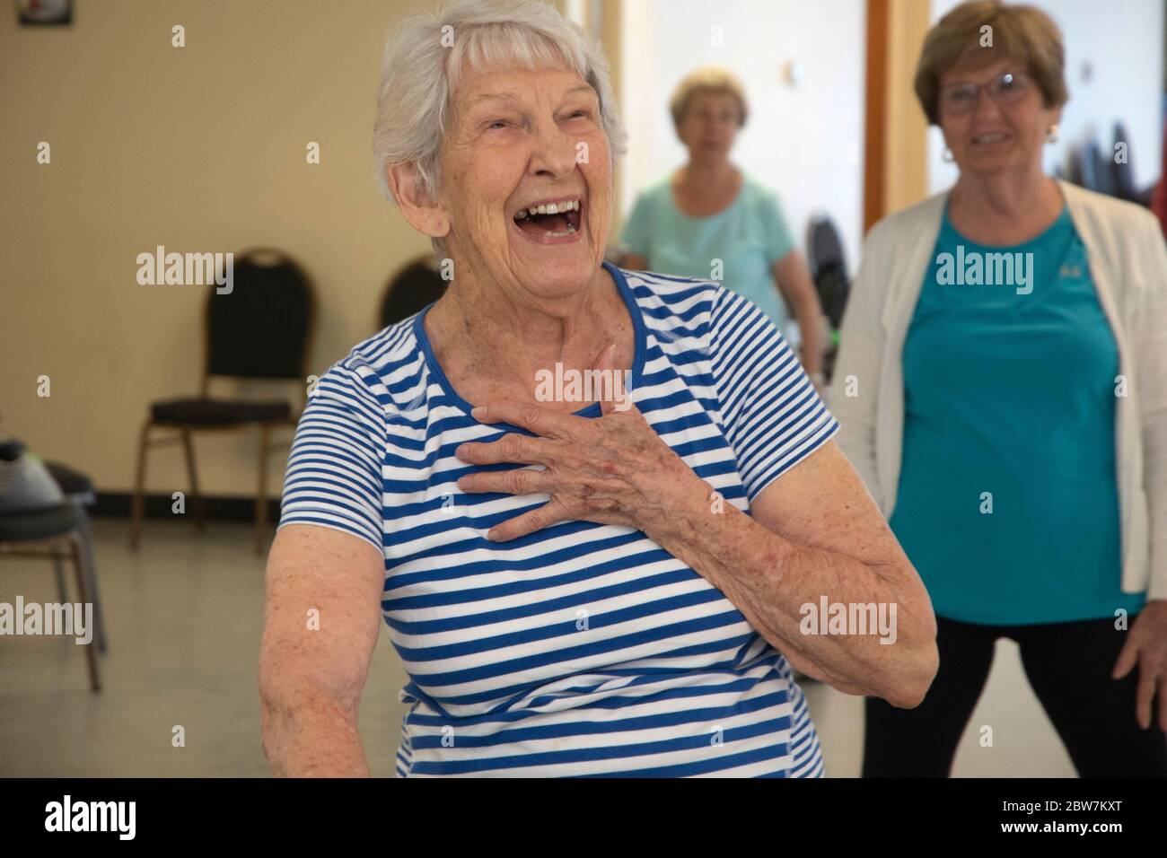 Una donna anziana sorride tutti mentre celebra il suo 99esimo compleanno alla lezione di allenamento YMCA a Punta Gorda, Florida. Foto Stock
