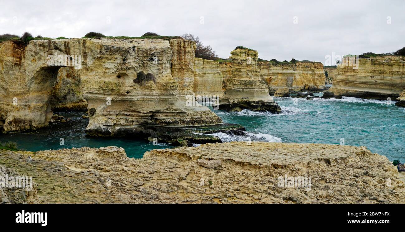 Paesaggio pittoresco con scogliere, arco roccioso e faraglioni, a Torre Sant Andrea, Costa del Salento, Puglia, Italia Foto Stock