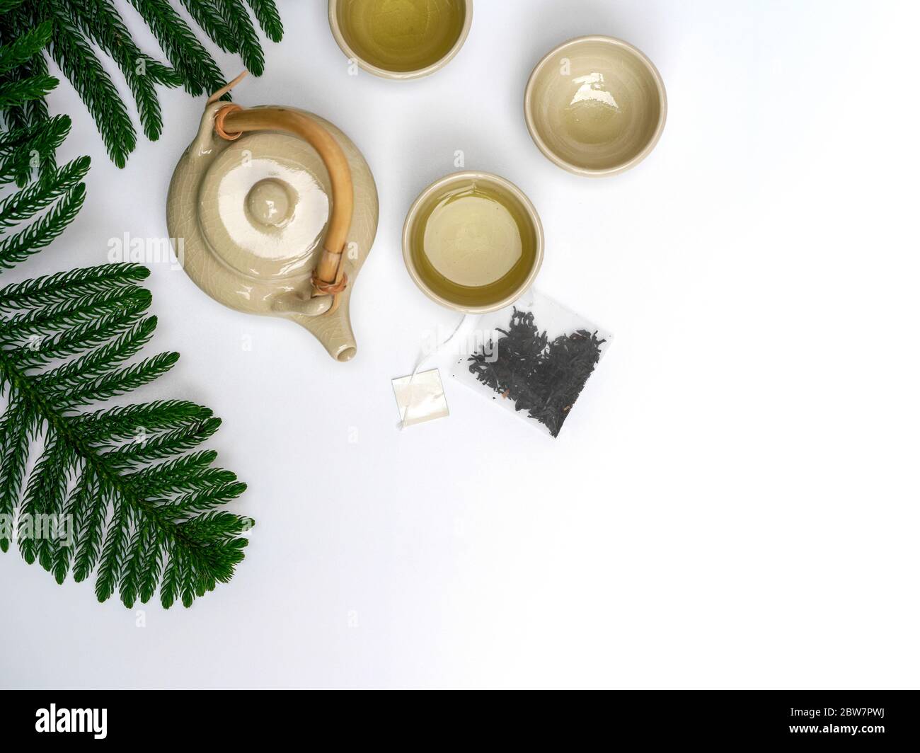 Un set di teiera in ceramica con manico in legno sul tavolo. Teabag con etichetta bianca. Foto Stock