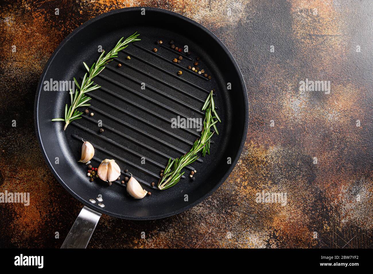 grigliate con barbecue, padella o padella su superfici rustiche di metallo con erbe per cucinare il concetto di vista dall'alto per testo o oggetti. Foto Stock