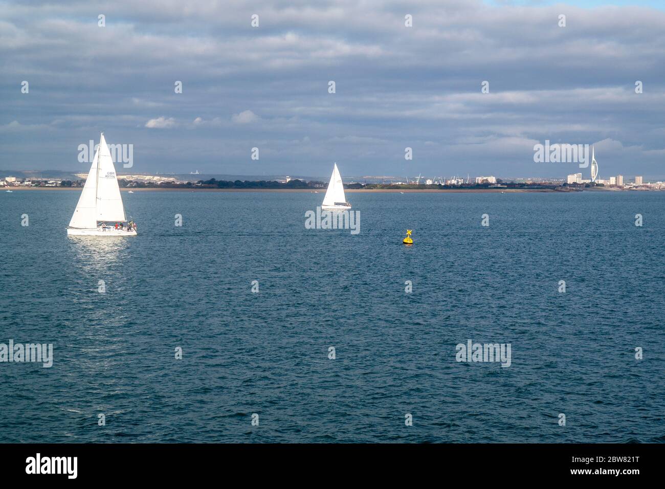 Vista di due yacht a vela sul Solent in un fresco pomeriggio di novembre con Portsmouth sullo sfondo Foto Stock