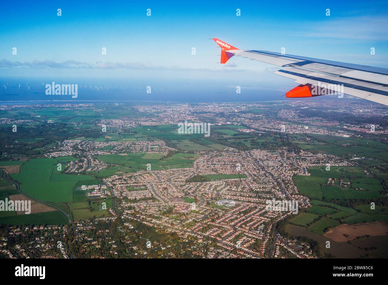 Guardando fuori dalla finestra dell'aereo, ala dell'aereo, aereo facile che vola sul fiume Mersey all'aeroporto John lennon di Liverpool, M. Foto Stock