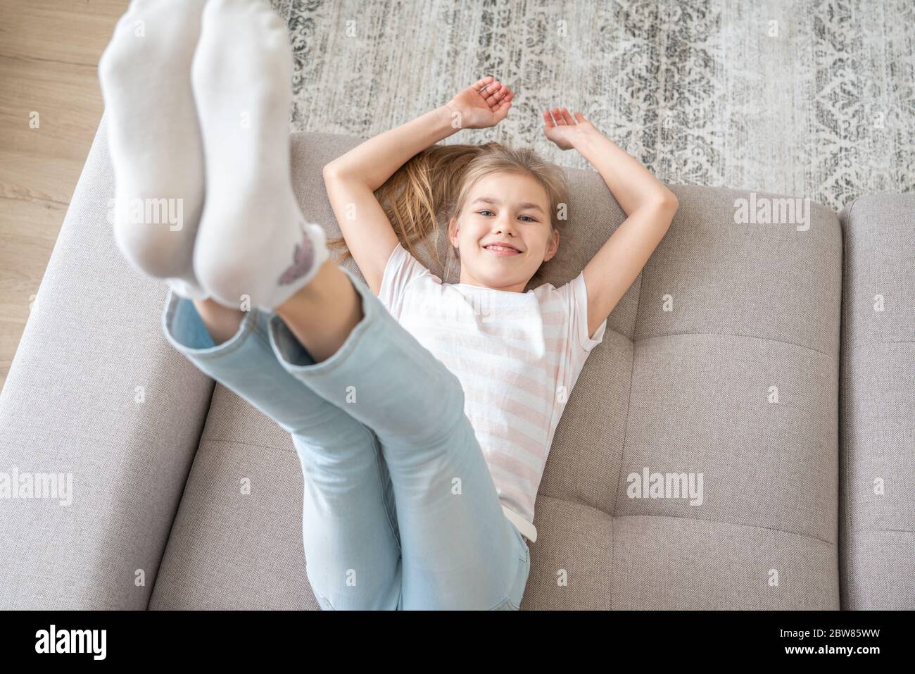 Presteen ragazza che si trova sul divano con i suoi piedi che si alzano in  alto Foto stock - Alamy