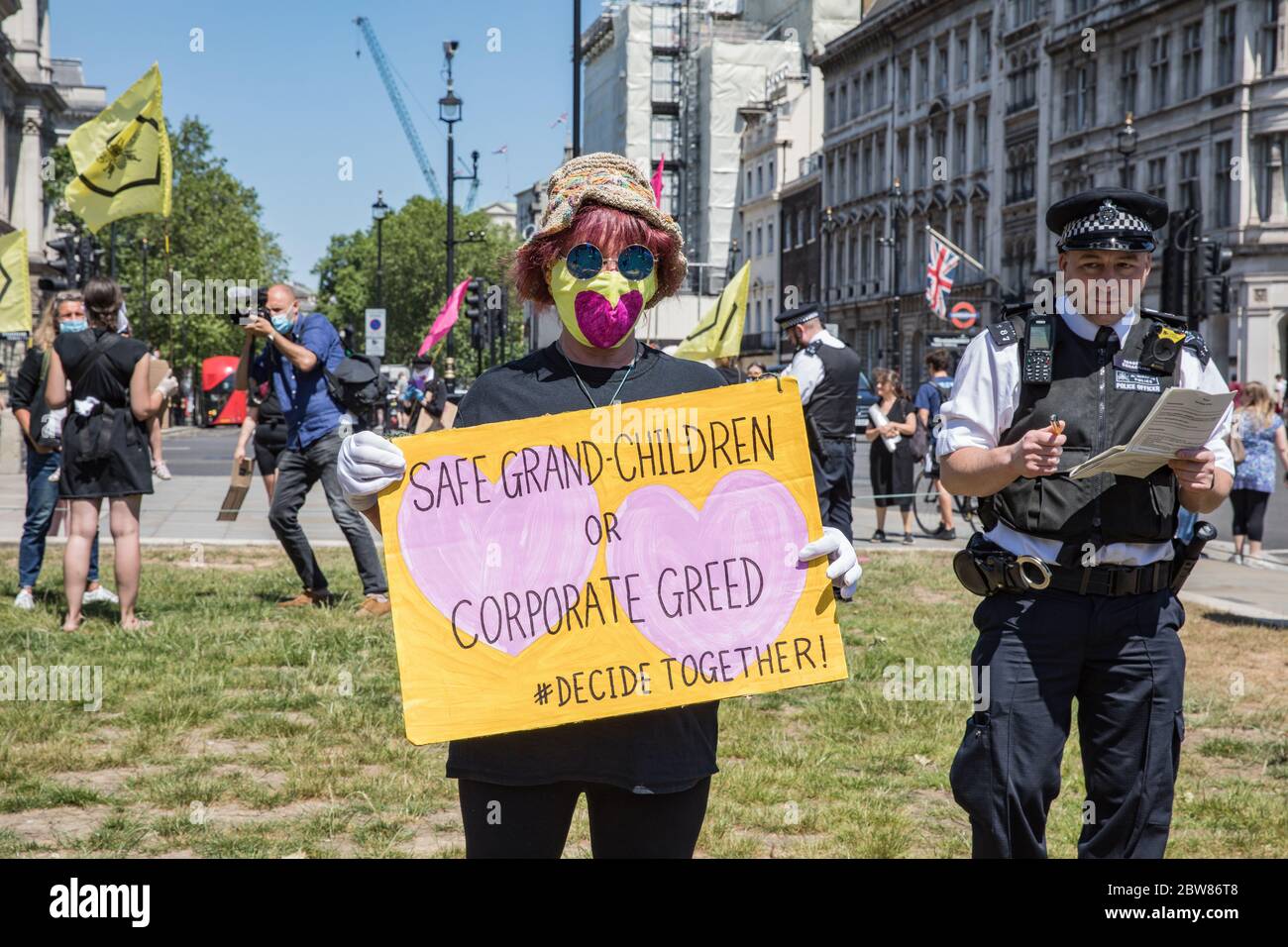 Parliament Square, Londra, Regno Unito. 30 maggio 2020. Alcune centinaia di attivisti ambientali della ribellione per l'estinzione dimostrano pacificamente in Piazza del Parlamento. I manifestanti tengono cartelli, chiedono un’azione decisiva da parte del governo britannico sulla crisi ambientale globale. Gli attivisti sono in piedi con maschere e mantengono un adeguato distanziamento sociale. La polizia ha interrogato i singoli attivisti che li spingono ad andare avanti; alcuni sono corpo cercato e gli arresti seguono per violazione delle norme Covid-19. Foto Stock