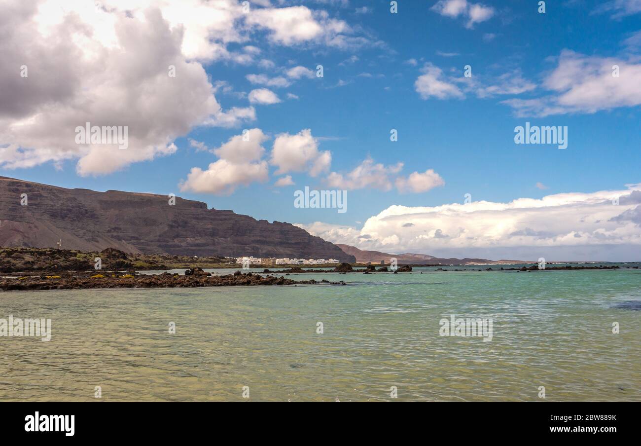 Sabbia bianca e rocce laviche nere sulla spiaggia di Caleton Blanco, Lanzarote, Isole Canarie, Spagna. Spiaggia vulcanica di Lanzarote, Canarie, Spagna Foto Stock