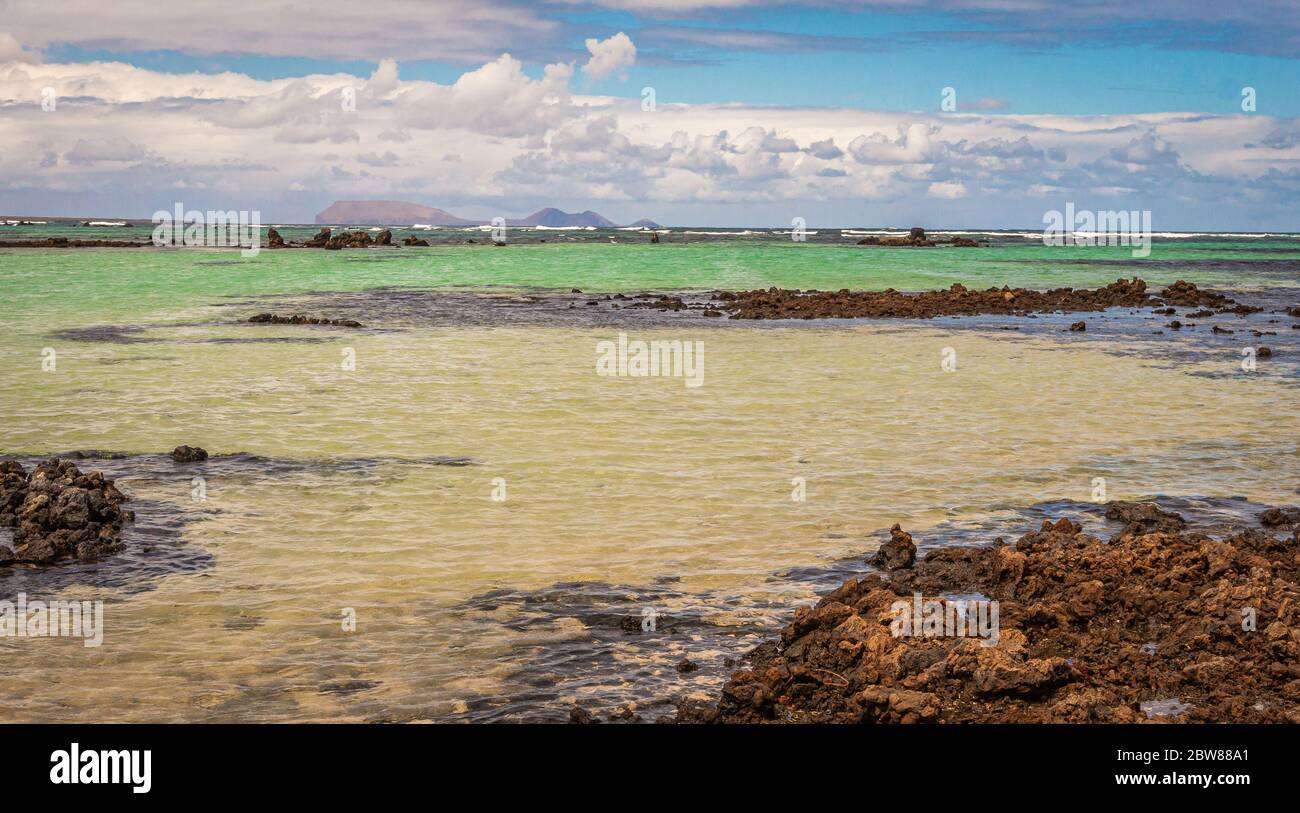 Sabbia bianca e rocce laviche nere sulla spiaggia di Caleton Blanco, Lanzarote, Isole Canarie, Spagna. Spiaggia vulcanica di Lanzarote, Canarie, Spagna Foto Stock