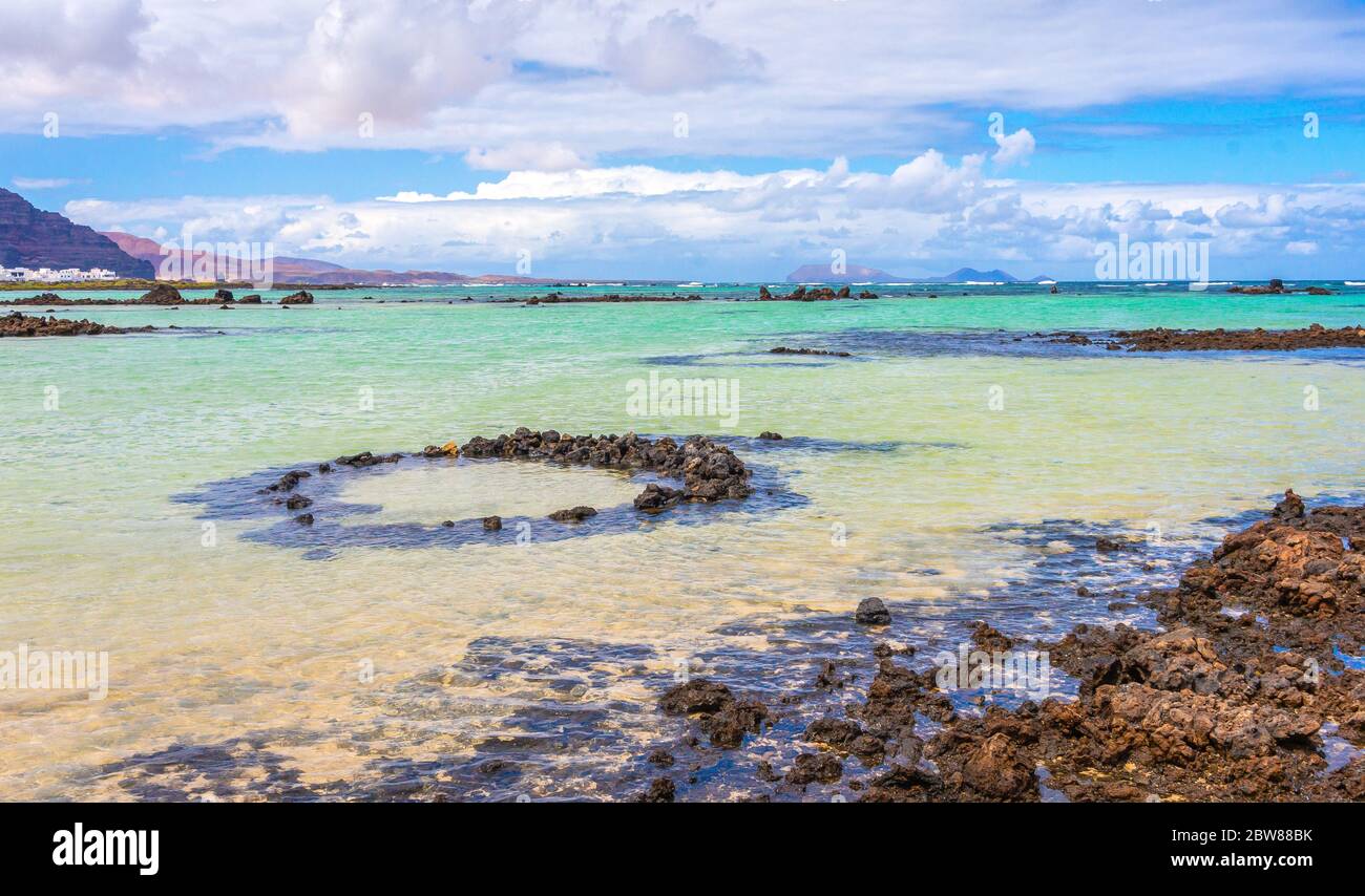 Sabbia bianca e rocce laviche nere sulla spiaggia di Caleton Blanco, Lanzarote, Isole Canarie, Spagna. Spiaggia vulcanica di Lanzarote, Canarie, Spagna Foto Stock