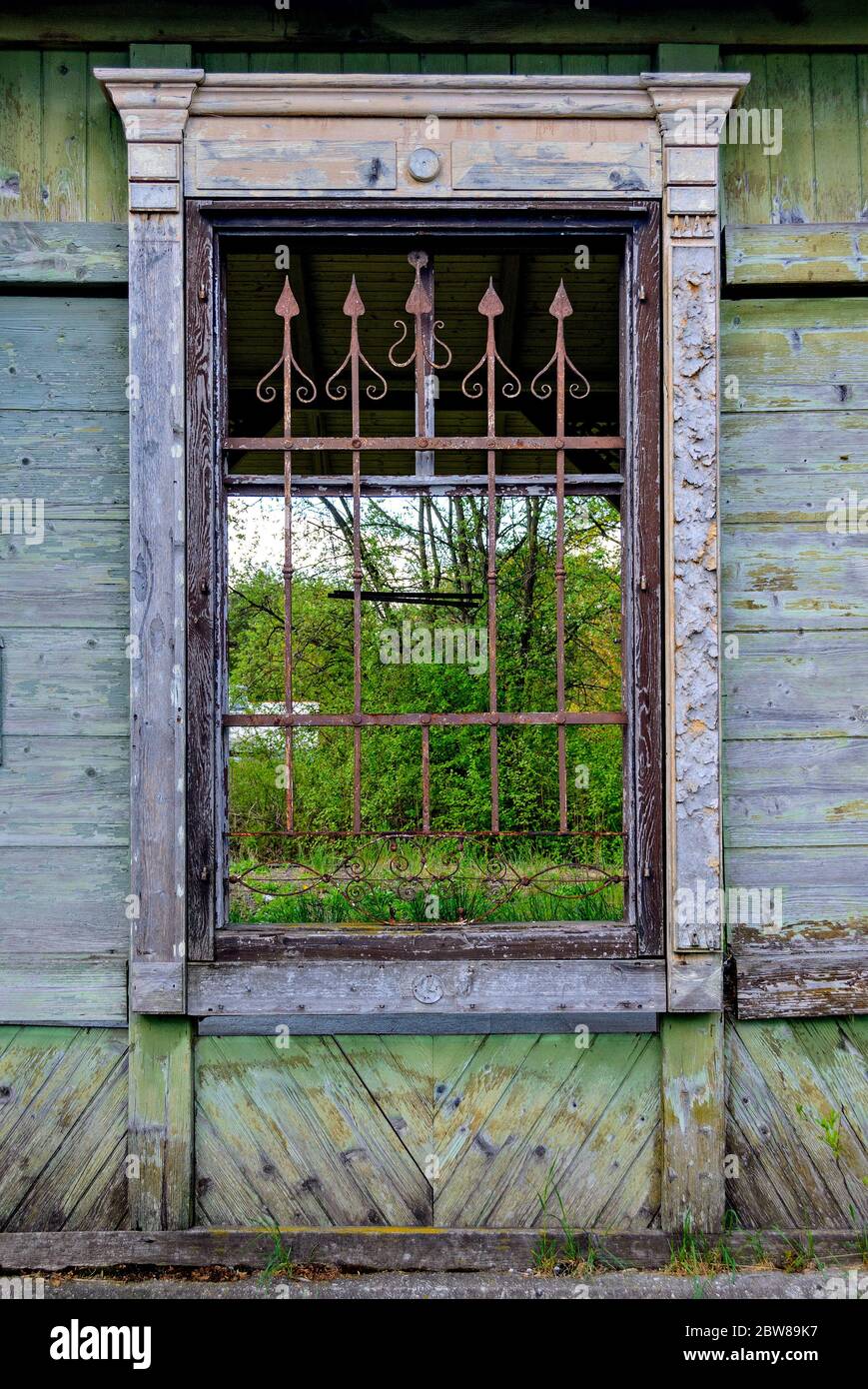 Vecchia finestra a reticolo con punte arrugginite in una desolata ex stazione ferroviaria in Austria Foto Stock
