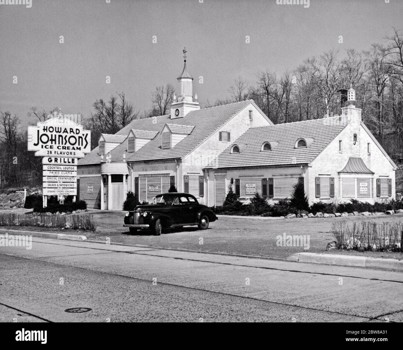 1940 HOWARD JOHNSON ROAD SIDE RESTAURANT SIGNS CHIUSO PER LA DURATA DELLA SECONDA GUERRA MONDIALE A CAUSA DELLA CARENZA DI BENZINA FORZA LAVORO FORT LEE NJ USA - Q43062 CPC001 HARS CARENZA ESTERNI GUERRE MONDIALI GUERRA MONDIALE GUERRA MONDIALE DUE NJ OCCUPAZIONI POLITICA IMMOBILIARE CONCETTO BENZINA STRUTTURE CONCETTUALI EDIFICIO CONCETTI SIMBOLICI COOPERAZIONE HOWARD JOHNSON ROAD SIDE SOLUZIONI IN BIANCO E NERO DUE DURATA ICONICA LEE MANPOWER RAPPRESENTAZIONE IN VECCHIO STILE Foto Stock