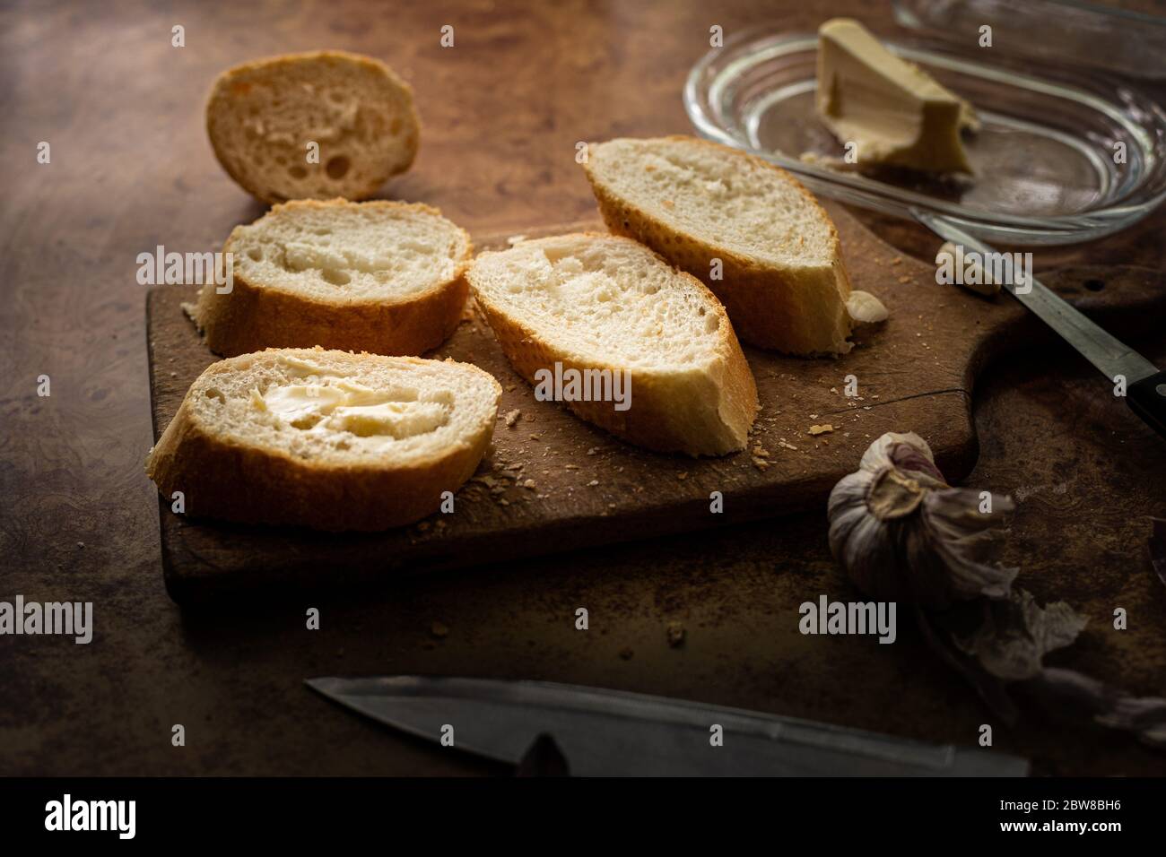 Baguette con burro e aglio. Colazione rustica. Cottage di campagna. Foto Stock