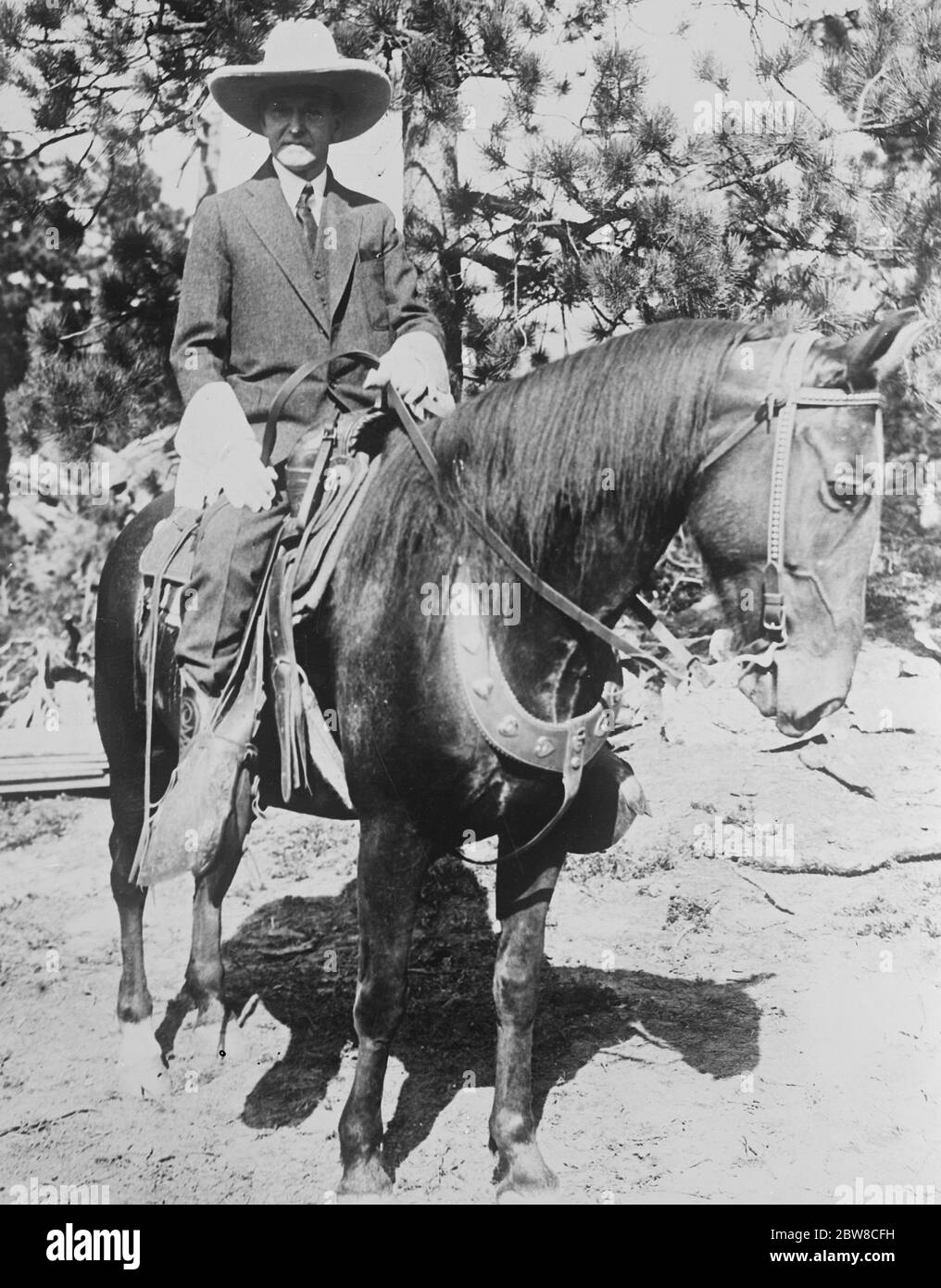 Il presidente Coolidge sul suo monte preferito durante la sua vacanza nelle colline nere in Dakota . Il presidente Calvin Coolidge , cavalcare il suo supporto preferito e indossare un cappello da cowboy e guuntlet durante la sua vacanza nelle Black Hills del North Dakota . 27 agosto 1927 Foto Stock