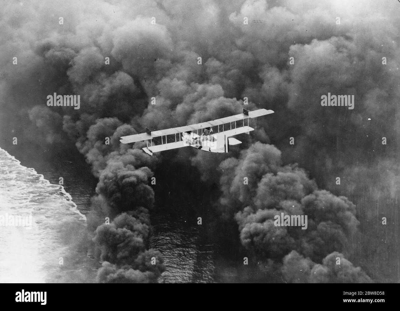 Un regolacapelli delle nuvole . Una suggestiva immagine aerea di un idrovolante navale statunitense, bilanciato su un denso schermo di fumo disposto dai cacciatorpediniere al largo della costa della California meridionale . 24 febbraio 1927 Foto Stock