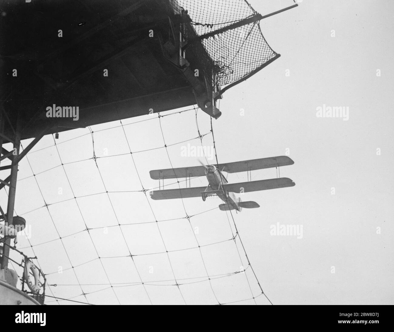 Come atterrano gli aerei su un aerodromo galleggiante . Un aereo navale in procinto di atterrare vicino a San Diego sul ponte della portaerei statunitense USS Langley . Notare la schermatura del filo di schermatura per evitare che il piano si appolga sul piano inferiore . 3 dicembre 1926 Foto Stock