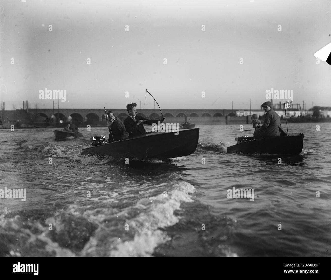 Tiro con l'arco da barche a motore su Harp gallese , Hendon . Un moderno bowman britannico perde dalla sua barca a motore al bersaglio ormeggiato e segna un colpo . 8 gennaio 1928 Foto Stock