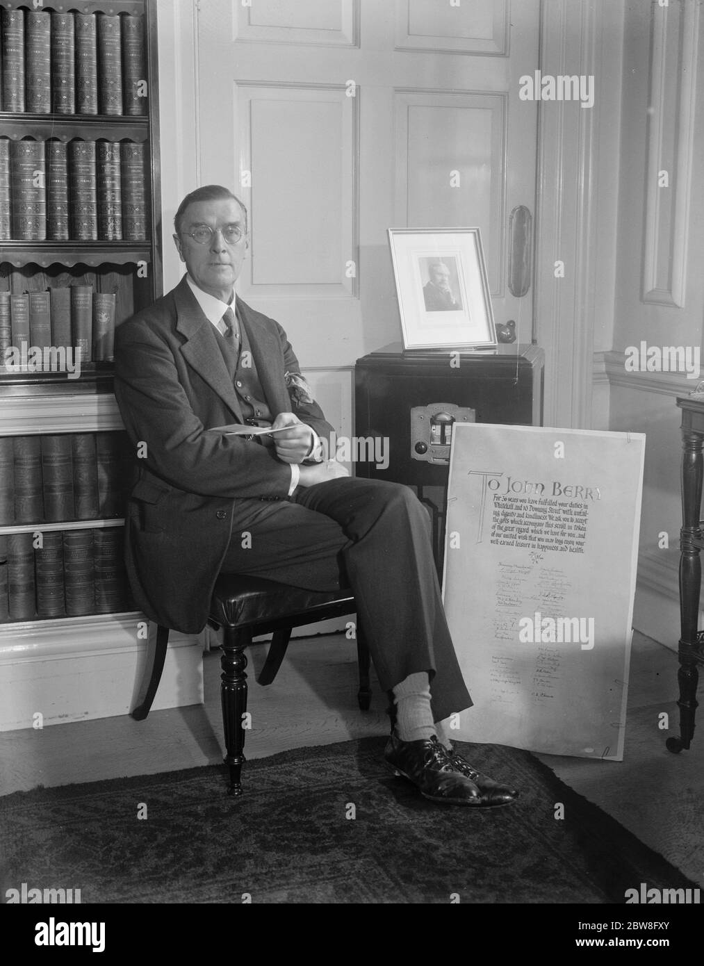 Presentazione al funzionario di Downing Street . John Berry che è stato nel servizio del Tesoro dal 1895 e dal 1922 è stato custode di ufficio a 10 Downing Street è stato presentato dal primo ministro con un assegno , wireless set e uno scross illuminato , iscritto da una lunga lista di amici in occasione del suo imminente pensionamento . Il signor John Berry con i suoi doni . 1 agosto 1931 Foto Stock