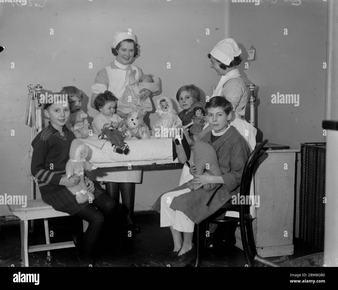 I giocattoli di natale della Regina per bambini nell' Ospedale della Regina Maria . La Regina ha inviato un regalo di giocattoli ai bambini del Queen Mary's Hospital for the East End , Stratford , E15 . Alcuni dei Medici , infermieri e bambini , con i Giocattoli reali . 20 dicembre 1933 Foto Stock
