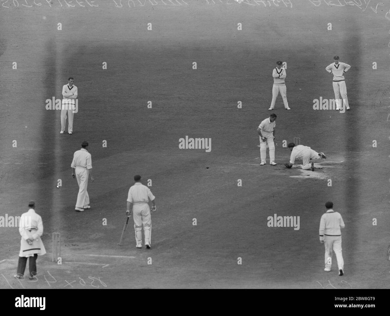 Test Match , Oval , quinto giorno ( di gioco ) ( sesto giorno di partita ) . Sutcliffe sfregò la coscia dopo essere stata colpita da una palla da Fairfax , mentre Oldfield , il guardiano australiano del wicket , scivola sul campo grasso . Nota l'uso libero di segatura . 1930 Foto Stock