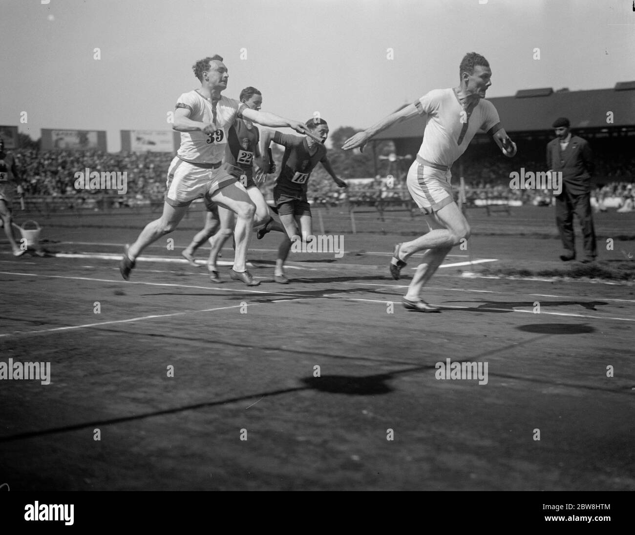 Partite britanniche al ponte Stamford lunedì di Pentecoste . Inghilterra ( bianco ) che cambia nel campo atletico 440 yarde relè . 9 giugno 1930 Foto Stock