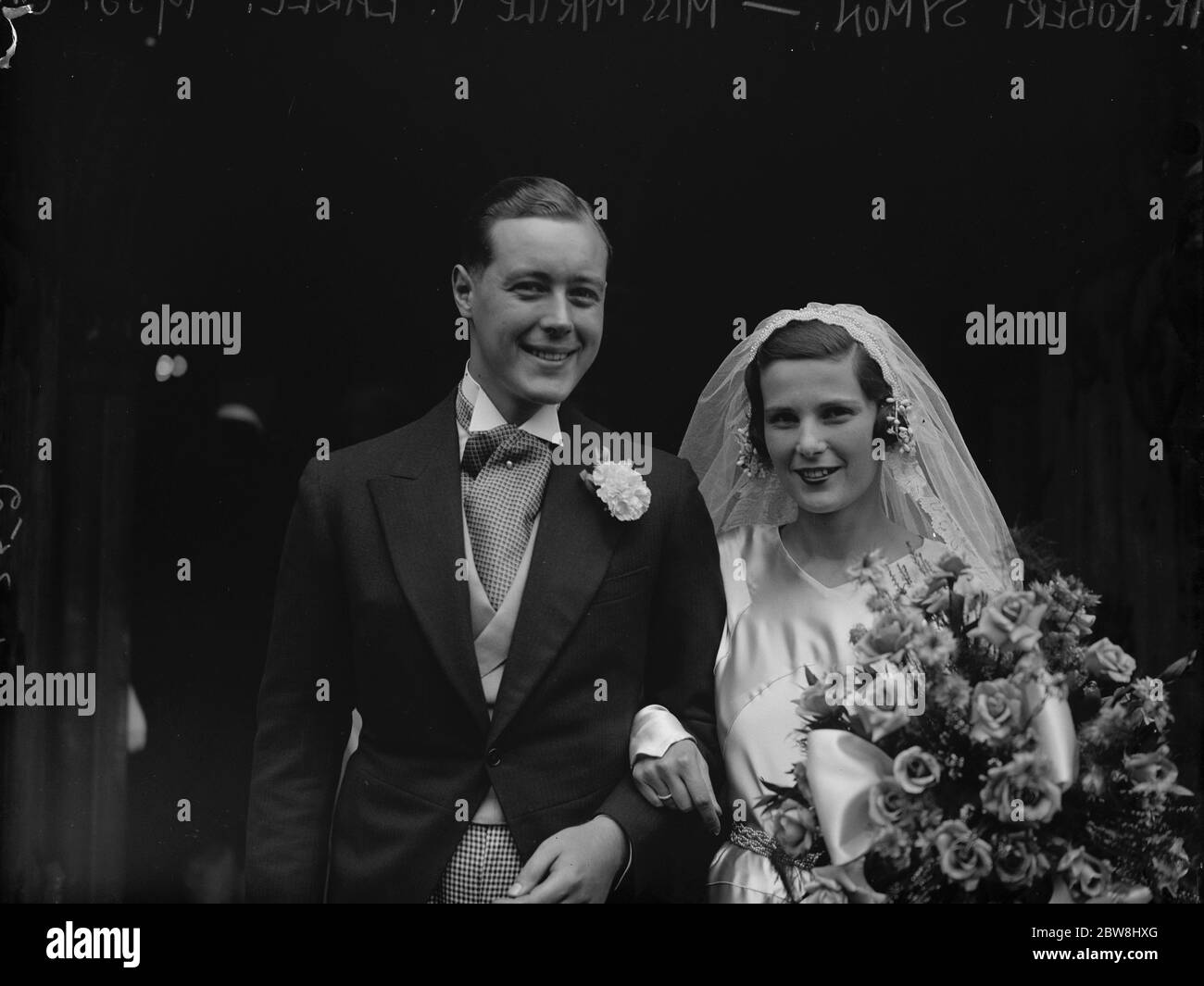 Un antico velo al matrimonio sociale a Pimlico . La sig.na Myrtle Valentin Earle , sposata con il sig. Robert Symon a St Barnaba, Pimlivo . Il velo della sposa del vecchio merletto di Bruxelles apparteneva una volta alla sua nonna, l' ex contessa di Ashburnham. Lo sposo e lo sposo . 22 luglio 1933 Foto Stock