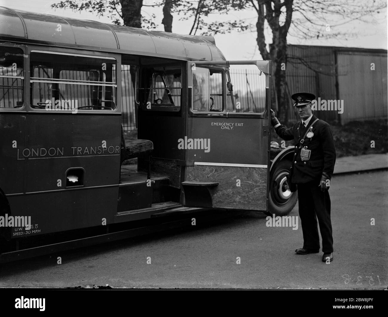 Un conduttore di bus che mostra la grande porta di accesso su un bus diesel , Longfield . 1935 . Foto Stock