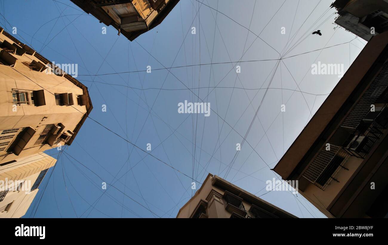Cavi elettrici appesi agli edifici di Mumbai. Foto Stock