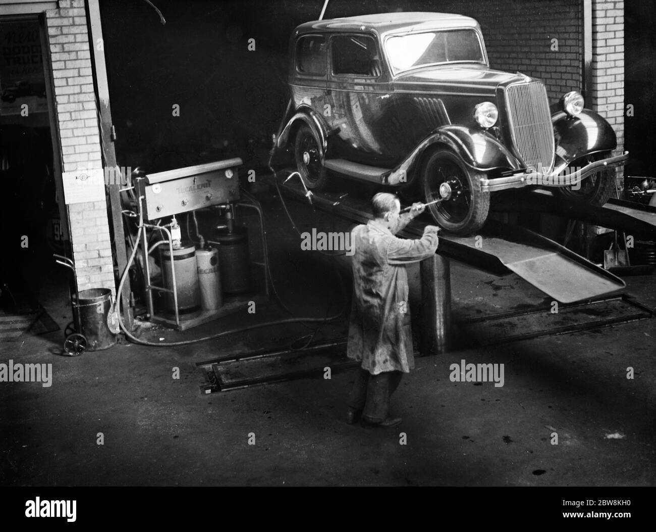 Pulizia di un'auto su un'emissione di un tecnoprodotto . 1935 . Foto Stock
