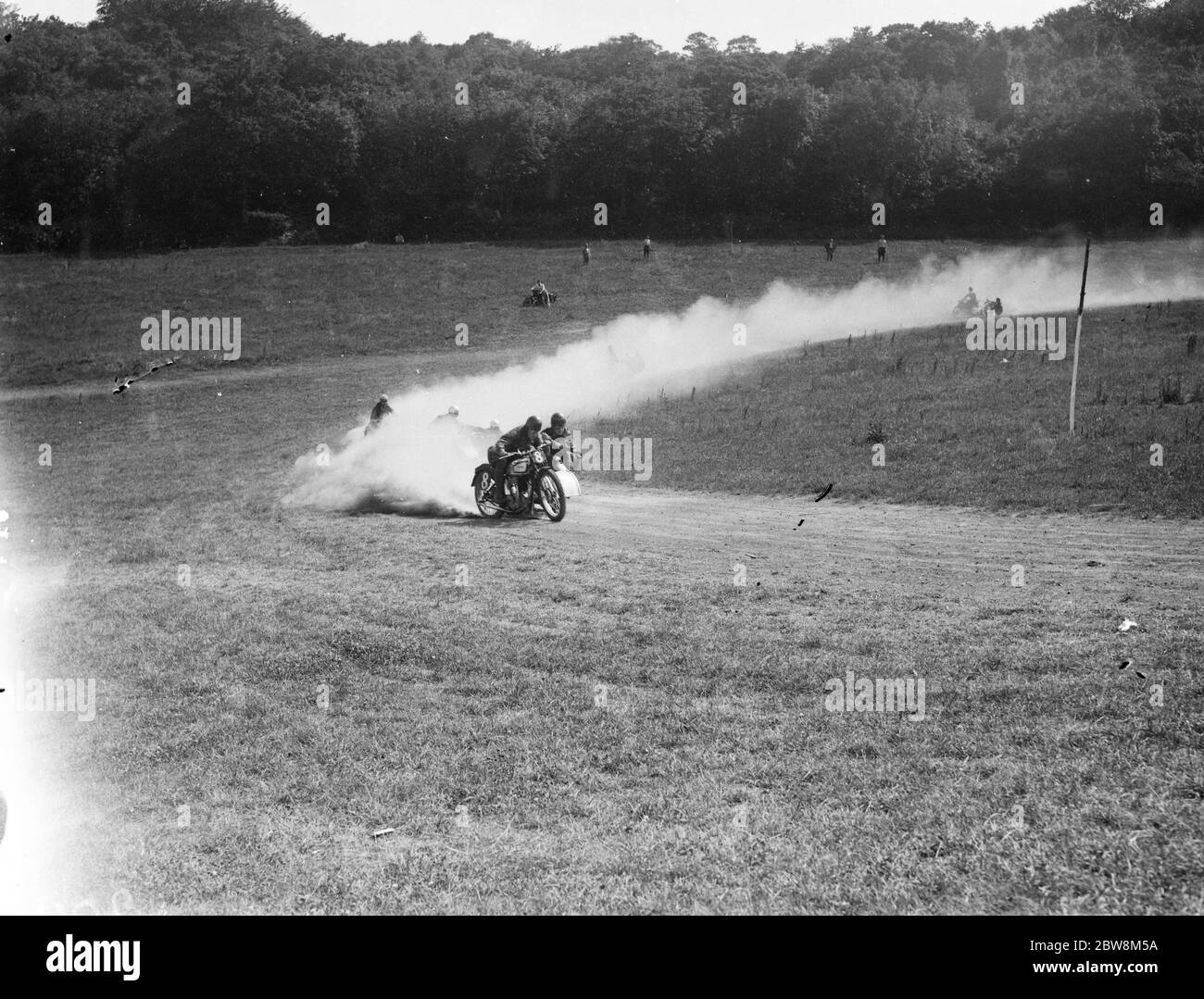I concorrenti del sidecar del ciclo del motore che si stanno buttando via la polvere mentre escono dall'angolo . 1935 . Foto Stock