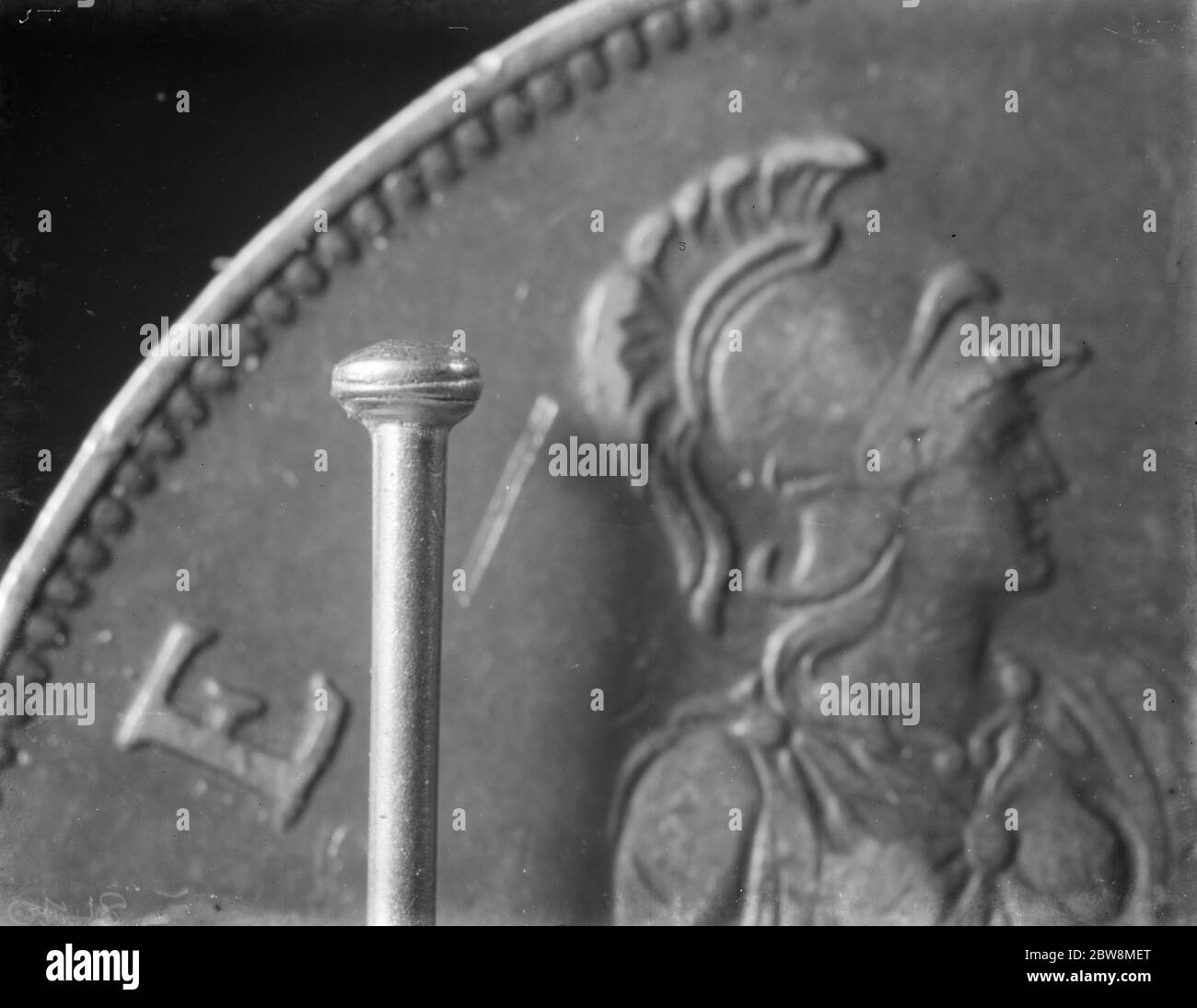 Una testa di perno accanto ad un pezzo di un centesimo . 12 aprile 1938 Foto Stock