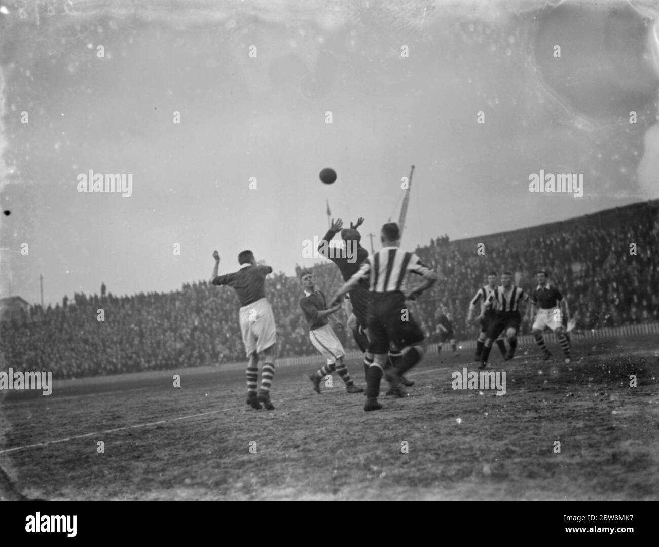 Squadra di calcio della Millwall contro il Notts County Football Club . Un portiere compete per la palla . 1936 Foto Stock