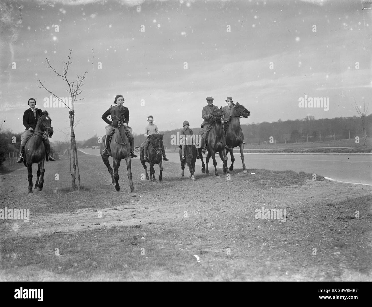 Cavalieri cavalcano sul sentiero lungo la tangenziale. 1936 . Foto Stock