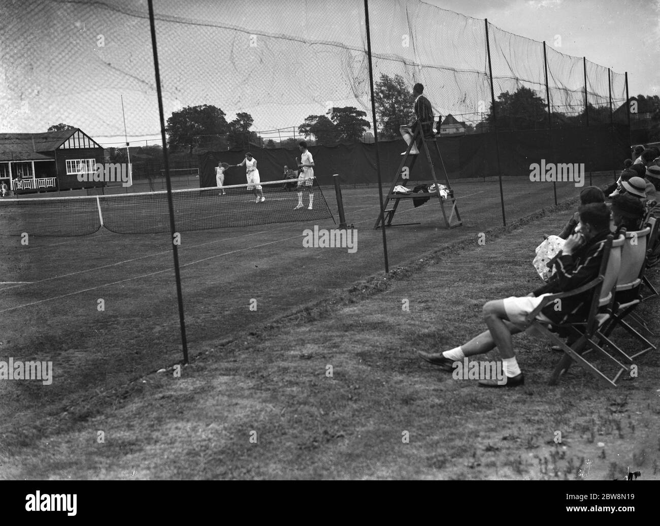 Spettatori che guardano una partita di tennis mista doppia . 1935 Foto Stock