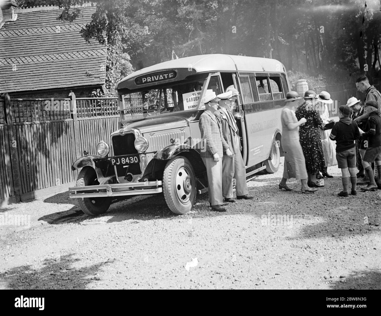 Autisti in piedi presso il loro Londra trasporto Bedford autobus essere utilizzato per un noleggio privato con scout cucciolo vendita di biglietti per un'escursione. 1935 Foto Stock