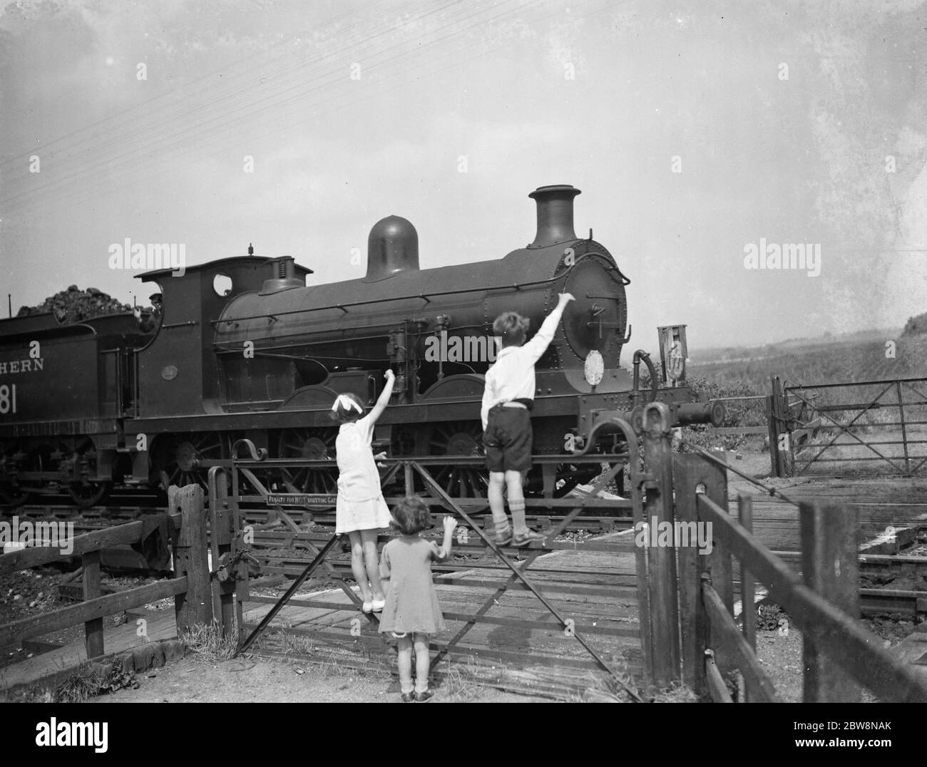 i bambini che si fermano al conducente del treno. 1936 Foto Stock