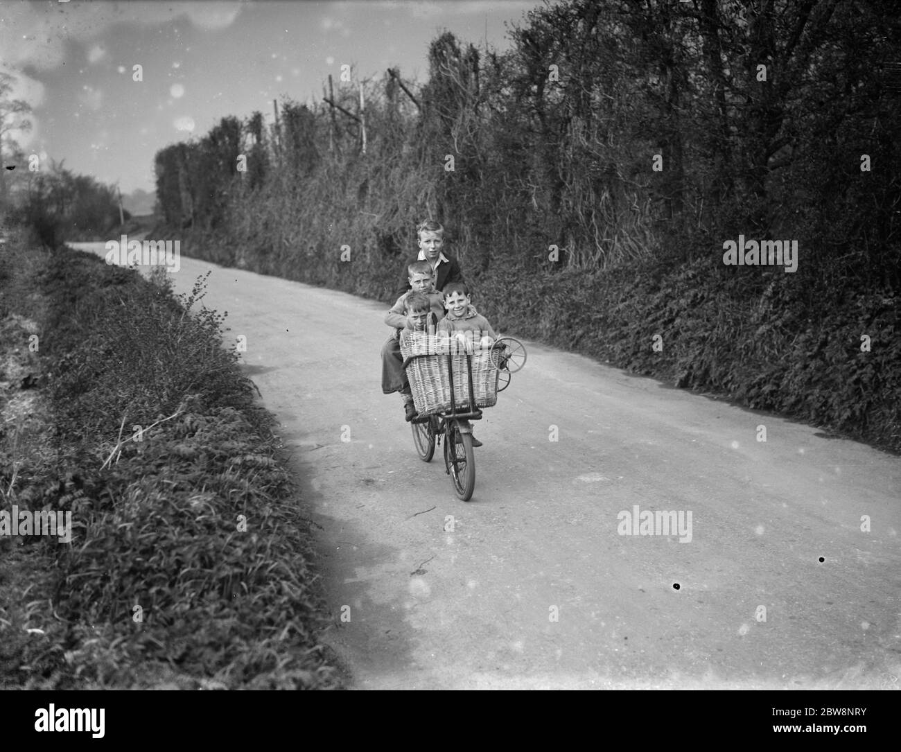 Quattro bambini in bicicletta nel paese . 1936 Foto Stock