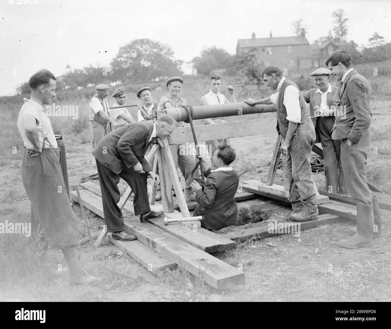 Un uomo che viene abbassato nel buco di Dene a Crayford da un sistema di pulegge . 1935 Foto Stock