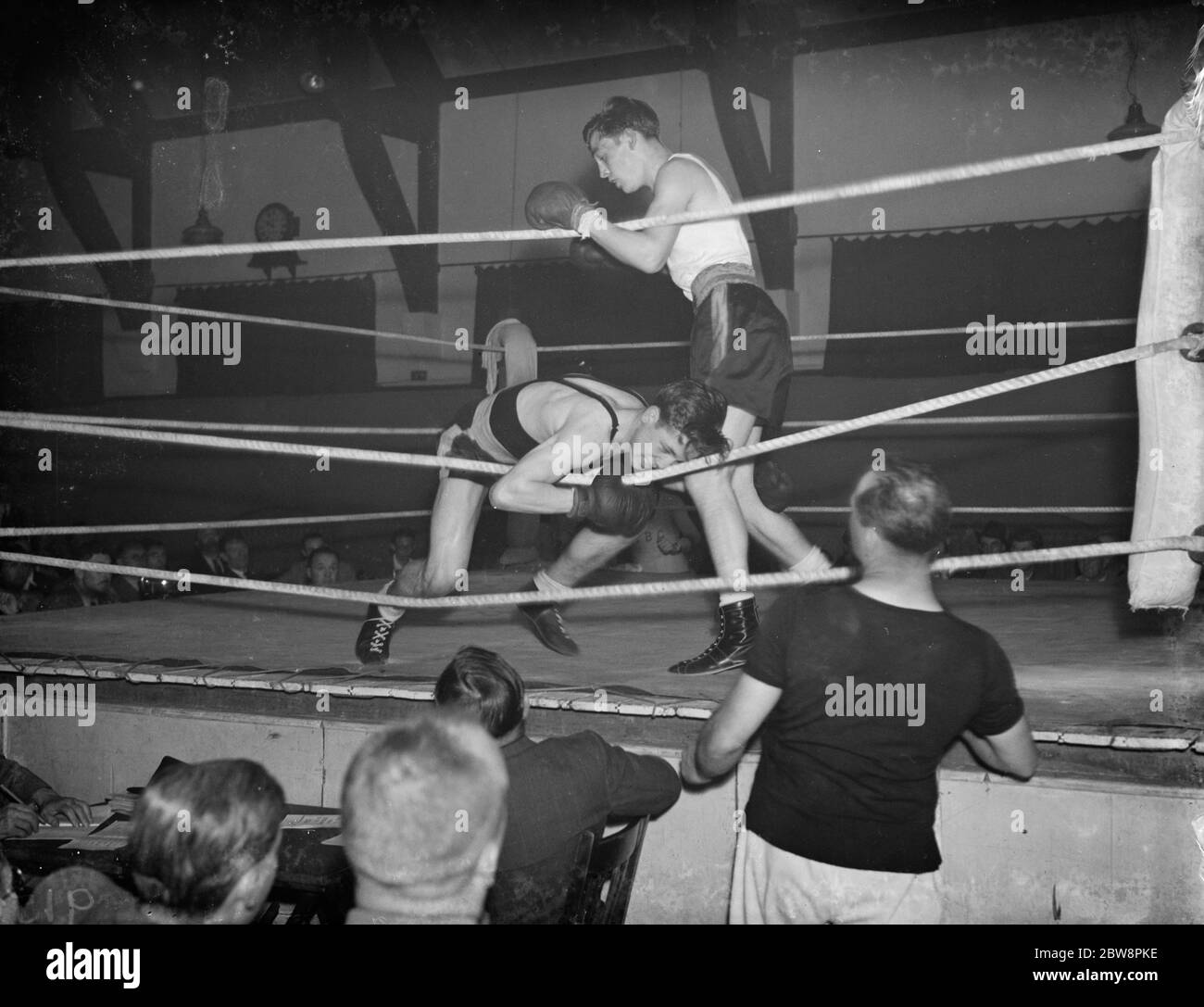 Un torneo di pugilato a Eltham . Jackie Fields, medaglia d'oro olimpica di pugilato, guarda l'azione nell'anello . 1938 Foto Stock