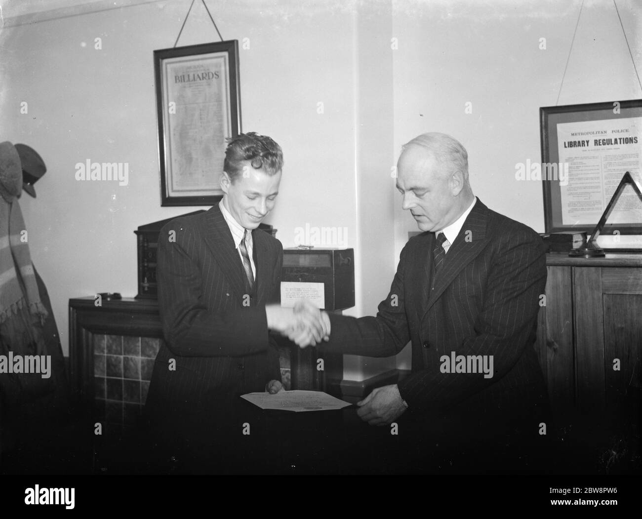 Il giovane eroe di Beckenham, Norman Woodward , (a sinistra), viene presentato con un certificato del Sovrintendente Collins . 1937 . Foto Stock