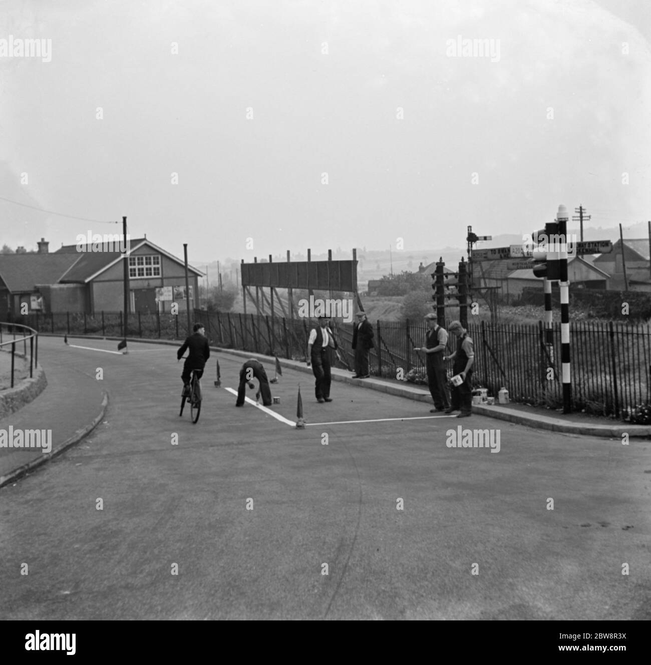 I lavoratori verniciano le indicazioni stradali sulla strada da alcuni semafori a Swanley . 1936 Foto Stock