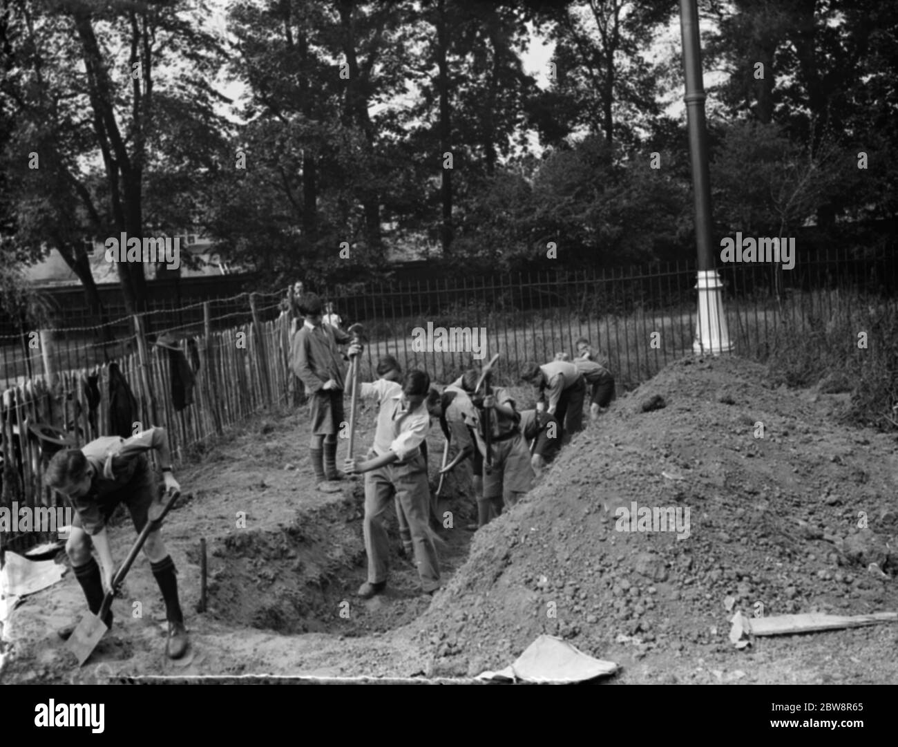 Gli scout Bridgen costruiscono la loro propria sede . Ragazzi scavando la fondazione fognaria . Foto Stock
