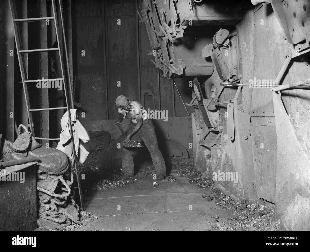 Il fornello del vaporizzatore a trampino,' Eston' che tovola carbone nella caldaia della nave. 1935 Foto Stock