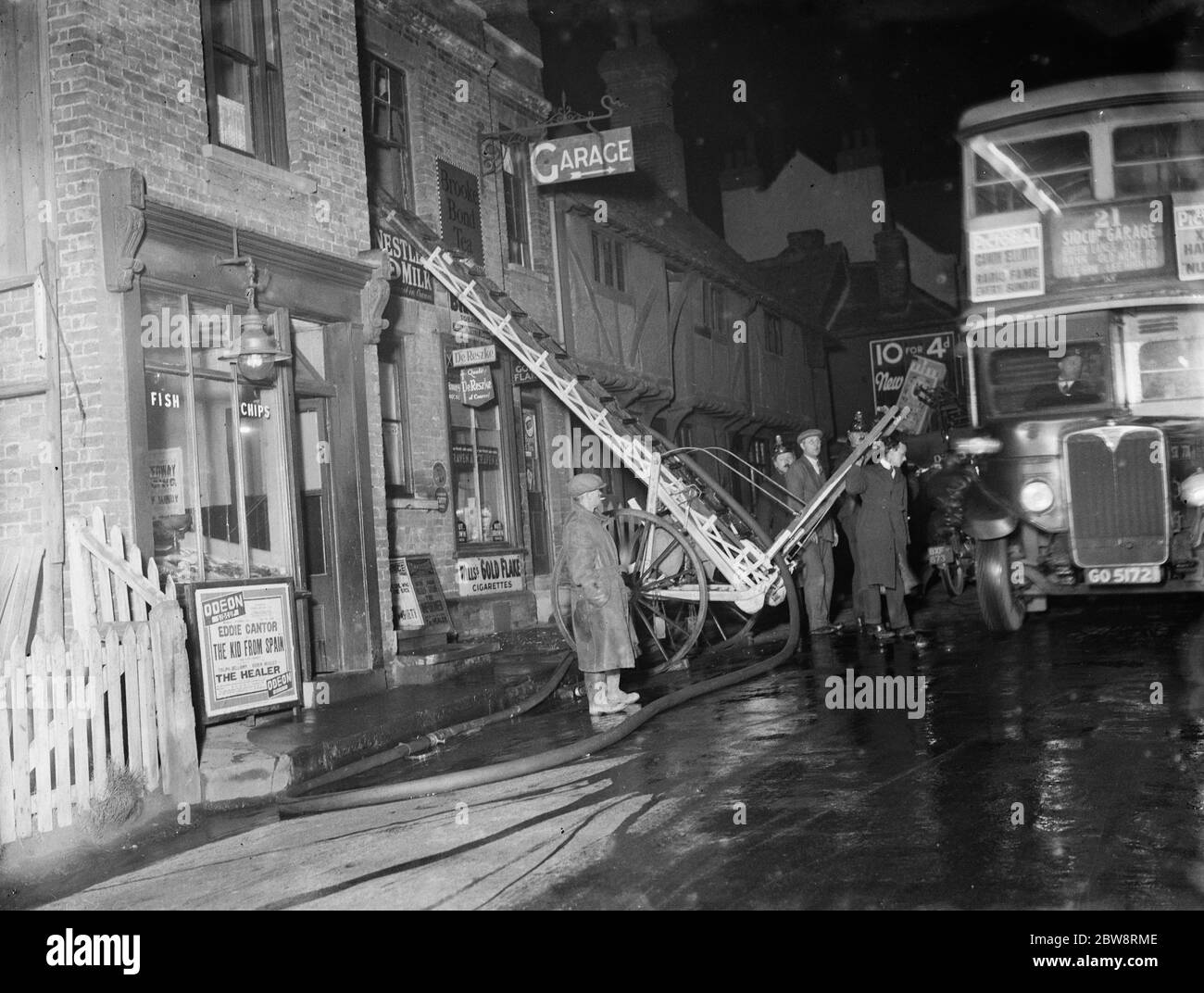 La brigata antincendio che si occupa di un incendio in un negozio di Foots Cray a Kent . . Una scala fino al finestrino del primo piano . 13 dicembre 1935 Foto Stock